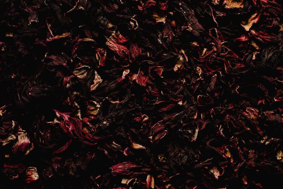 feuilles entières de thé noir Darjeeling avec bourgeons argentés sur fond de bois clair