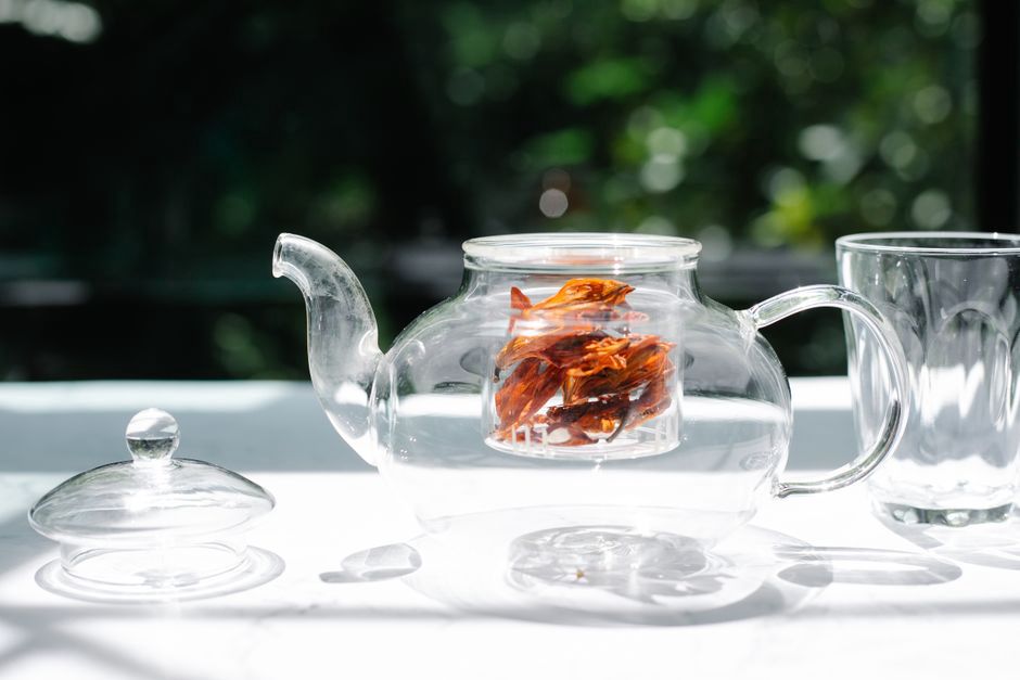 Infusion dorée avec fleurs et feuilles visibles