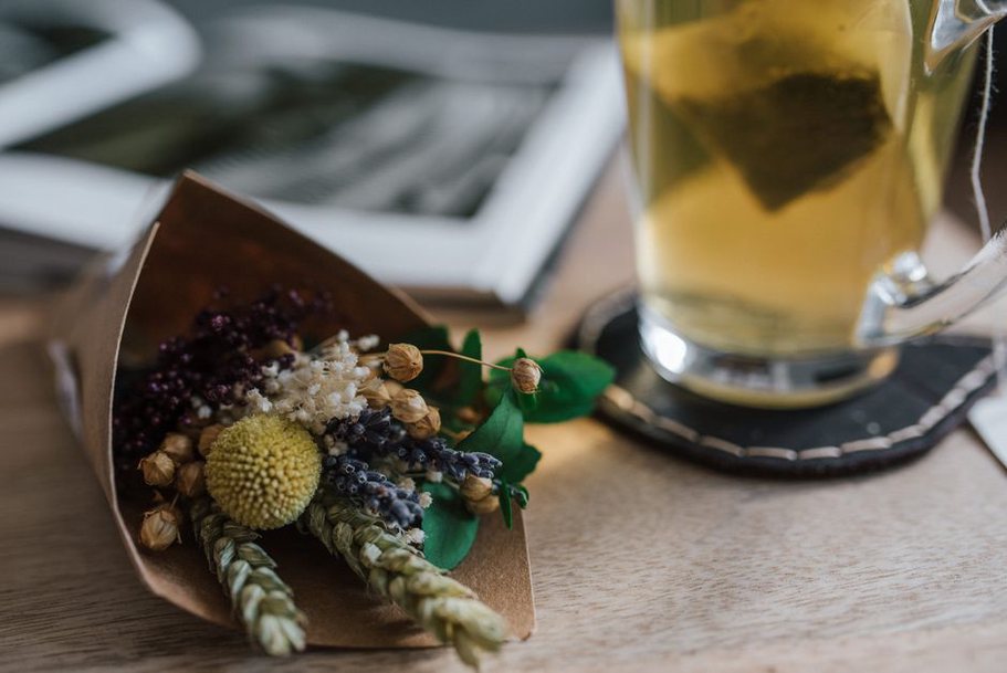 Une tasse de tisane près de fleurs séchées