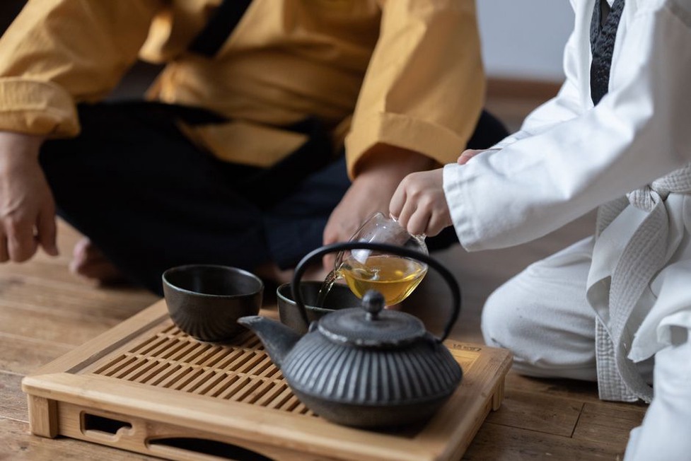 Une théière verse le thé dans de petites tasses