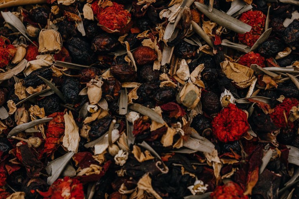 Mélange de fleurs, feuilles et fruits séchés dans un bol