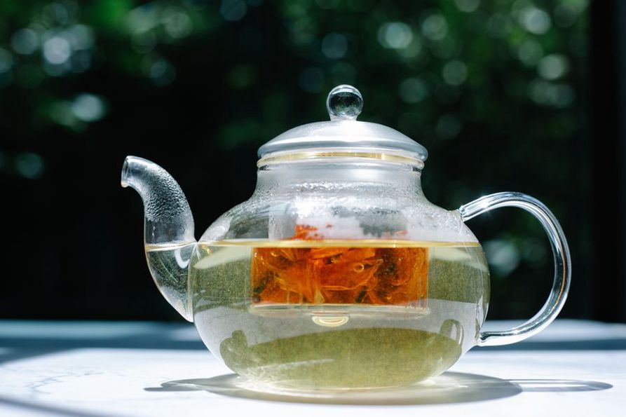 Les feuilles se déploient dans une théière en verre